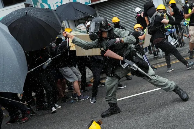A riot police officer clashes with demonstrators during a protest against the Yuen Long attacks in Yuen Long, New Territories, Hong Kong, China July 27, 2019. Police fired tear gas and rubber bullets at demonstrators hurling rocks in a rural Hong Kong town as several thousand activists gathered to protest an attack by suspected triad gang members at a train station the previous weekend. (Photo by Tyrone Siu/Reuters)