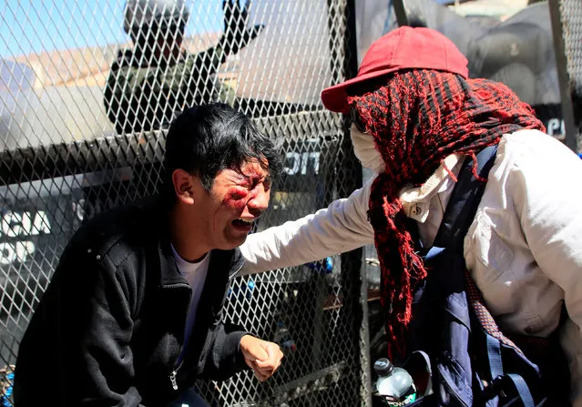 An injured demonstrator is helped by a comrade, during a protest by people with physical disabilities demanding the government to increase their monthly disability subsidy, in La Paz, Bolivia, April 29, 2016. (Photo by David Mercado/Reuters)