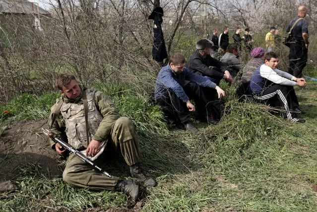 An Ukrainian soldier takes a rest with  local people in Kramatorsk, Ukraine, 16 April 2014. Pro-Russian protestors blocked a column of Ukrainian armored vehicles enroute to Slaviansk and did not allow them to pass. Pro-Russian insurgents, who are demanding broader autonomy from Kiev and closer ties to Russia, continued occupying government, police and other administrative buildings in eastern cities, in defiance of an ultimatum by the Ukrainian government to lay down their weapons. (Photo by Anastasia Vlasova/EPA)