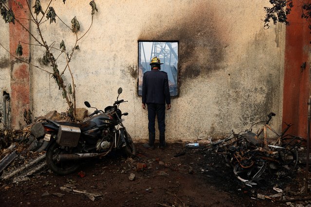 A fire brigade official looks at the wreckage after a blast at a chemical factory in Dombivli, on the outskirts of Mumbai, India on May 24, 2024. (Photo by Francis Mascarenhas/Reuters)