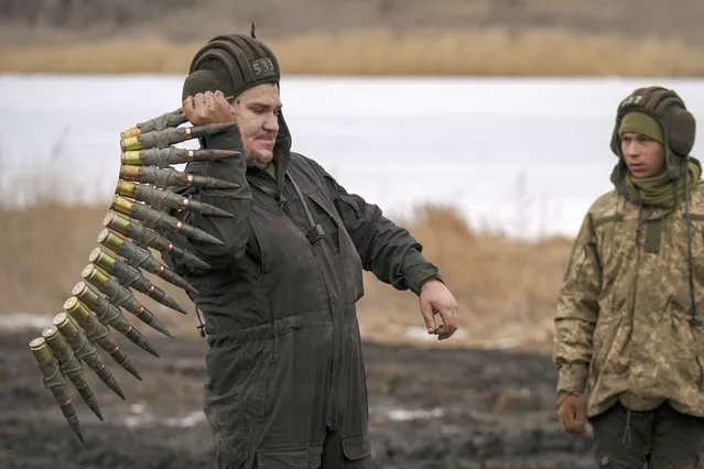 A Ukrainian serviceman handles large caliber ammunitions for armored fighting vehicles mounted weapons during an exercise in a Joint Forces Operation controlled area in the Donetsk region, eastern Ukraine, Thursday, February 10, 2022. A peace agreement for the separatist conflict in eastern Ukraine that has never quite ended is back in the spotlight amid a Russian military buildup near the country's borders and rising tensions about whether Moscow will invade. (Photo by Vadim Ghirda/AP Photo)