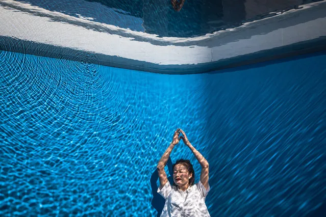 A woman poses for photos as she views the installation “Swimming pool” during an exhibition of Argentine conceptual artist Leandro Erlich, titled “The Confines of the Great Void”, at the CAFA Art Museum in Beijing, China, 13 August 2019. Erlich works in between reality and imagination with a focus around symbols, underlying meanings, and reality. The exhibit runs until 25 August 2019. (Photo by Roman Pilipey/EPA/EFE)