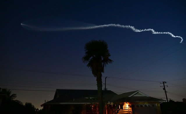 A SpaceX Falcon 9 rocket with a payload of 20 Starlink satellites is seen in the evening sky above Los Angeles, California after being launched from Vandenberg Space Force Base on June 18, 2024. (Photo by Frederic J. Brown/AFP Photo)