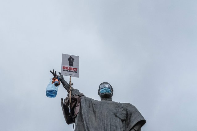 The statue of the late Kenyan Minister of Justice Tom Mboya, is adorned with a placard reading “Reject not Amend” ahead of a planned demonstration called after a nationwide deadly protest against a controversial now-withdrawn tax bill left over 20 dead in downtown Nairobi, on June 27, 2024. Kenyans are preparing to take to the streets on Thursday for a white march the day after President William Ruto announced the withdrawal of the draft budget providing for tax increases, at the origin of a protest which foundered in murderous violence. (Photo by Kabir Dhanji/AFP Photo)