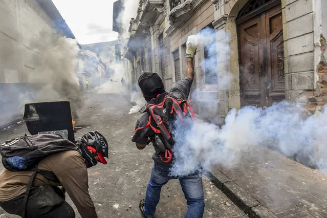 Demonstrators clash with riot police as thousands march against Ecuadorean President Lenin Moreno's decision to slash fuel subsidies, in Quito on October 9, 2019. Unions and other groups alongside thousands of farmers and indigenous people are expected in the streets of the capital Quito. Protests and clashes erupted in Ecuador a week ago, after the government doubled fuel prices as part of an agreement with the International Monetary Fund to obtain loans despite its high public debt. (Photo by Martin Bernetti/AFP Photo)