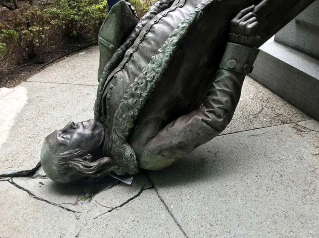In this photo released by the City of Boston Mayor's office, a statue of Benjamin Franklin lies on the concrete outside where it landed when knocked off its pedestal outside Old City Hall in Monday, May 16, 2016, in Boston. A spokesperson for the mayor said high winds pushed a nearby tent into the statue, causing it to fall off its pedestal. (Photo by City of Boston via AP Photo)