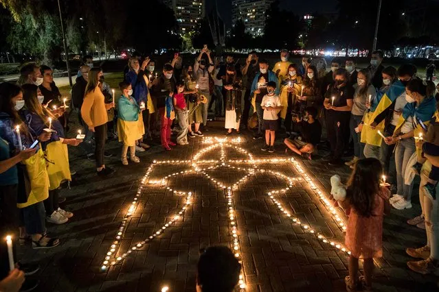 Members of the Ukrainian community take part in a vigil to protest against the the Russian invasion of Ukraine, in Santiago, on March 24, 2022. (Photo by Javier Torres/AFP Photo)