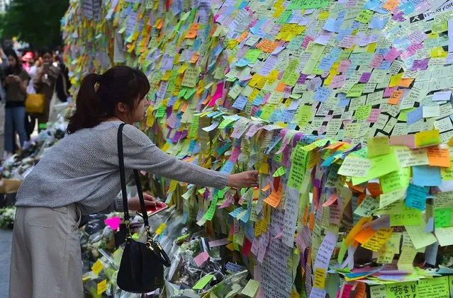 South Koreans leave messages written on post-it notes at an exit of Gangnam subway station, which has been turned into a mini shrine for a 23-year-old woman who was stabbed to death by a stranger the previous night in a nearby public bathroom, in Seoul on May 20, 2016. The brutal murder of a woman in Seoul's upmarket Gangnam district has triggered a public outcry and a debate over what some see as a growing streak of violent misogyny in South Korea. (Photo by Jung Yeon-Je/AFP Photo)