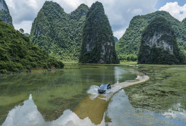 Vehicles drive on a “water highway” formed by floods along a rural road in Chongzuo city, South China's Guangxi Zhuang Autonomous region, June 23, 2024. (Photo by CFOTO/Future Publishing via Getty Images)