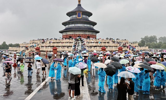 Tourists visit the Tiantan Park in the rain in Beijing, China, 25 July, 2024. (Photo by Rex Features/Shutterstock)