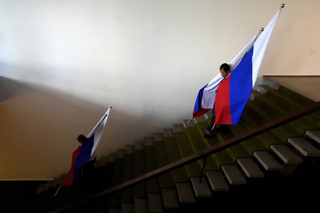 Employees of Itamaraty Palace carry Russian flags in preparations for the arrival of Russian Foreign Minister Sergey Lavrov in Brasilia, Brazil, Monday, April 17, 2023. Lavrov will meet with Brazil's Foreign Minister. (Photo by Eraldo Peres/AP Photo)