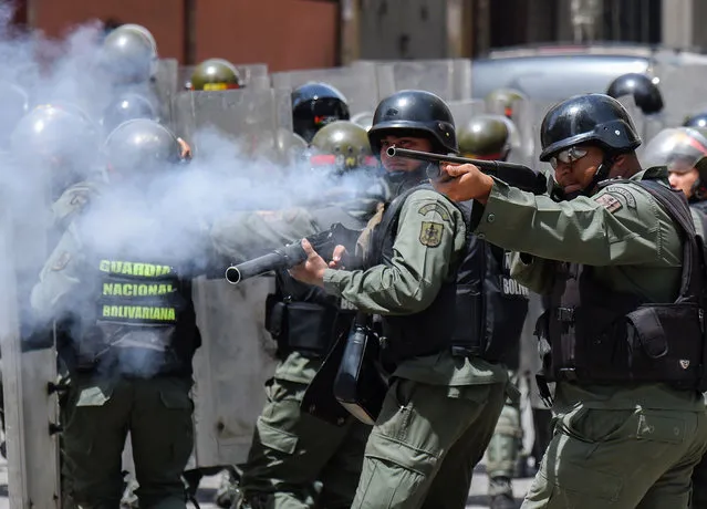 Security forces clash with people trying to reach Miraflores presidential palace to protest against the severe food and medicine shortages, in Caracas on June 2, 2016. Venezuelans face long lines at supermarkets tightly guarded by nervous soldiers, bare shelves and soaring prices inside, a dysfunctional health care system short on basic medications and supplies, daily power cuts of four hours across most of the country, and a government that only operates two days a week to save electricity. (Photo by Juan Barreto/AFP Photo)