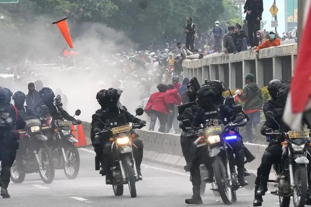 Police disperse protesters during a rally in Jakarta, Indonesia, Monday, April 11, 2022. Thousands of students marched in cities around Indonesia on Monday to protest against rumors that the government is considering postponing the 2024 presidential election to allow President Joko Widodo to remain in office beyond the two-term legal limit, calling it a threat to the country's democracy. (Photo by Tatan Syuflana/AP Photo)