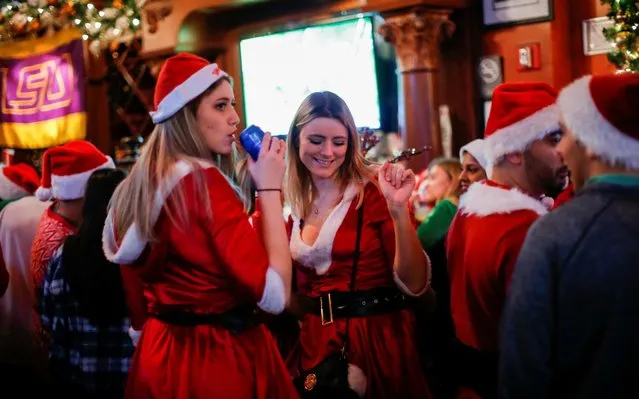 Revelers dressed as Santa Claus share drinks in a local bar as they take part in the event called SantaCon in New York City, U.S., December 14, 2019. (Photo by Eduardo Munoz/Reuters)