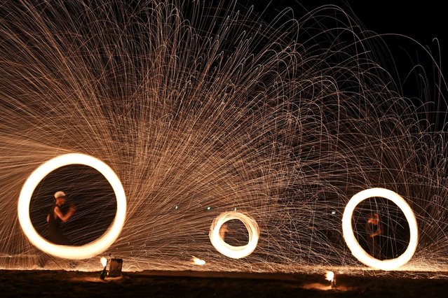 Fire dancers perform at a beach on the Thai island of Koh Samui on August 29, 2024. (Photo by Lillian Suwanrumpha/AFP Photo)