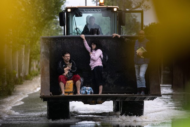 Residents are rescued on a digger on May 17, 2023 in Massa Lombarda, a small village about 10 kilometers from Imola, after heavy rains have caused major floodings in central Italy. Five people have died after heavy rains caused flooding across Italy's northern Emilia Romagna region, and the F1 Grand Prix, scheduled on Sunday in Imola, has been canceled. (Photo by Federico Scoppa/AFP Photo)