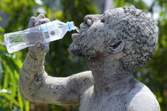 An Asaro mudman has a drink of water as Pope Francis gives an address during his meeting with young people at the Sir John Guise Stadium in Port Moresby, Papua New Guinea, Monday, September 9, 2024. (Photo by Mark Baker/AP Photo)