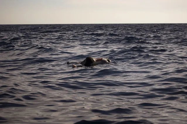 The dead body of a woman is seen floating on the Mediterranean sea, at 20 miles north of Zuwarah, Libya, on Wednesday, June 21, 2017. At least three bodies with sign of decomposition were found by aid organisations on Wednesday, apparently from a recent sinking boat in the area from people who were attempting the perilous crossing of the Mediterranean Sea to Europe in packed boats from Libya. (Photo by Emilio Morenatti/AP Photo)