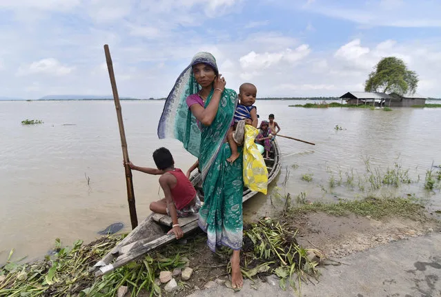 An Indian resident steps off a boat in the flood- affected village of Balimukh Ashigarh in Morigoan on July 5, 2017. Flooding has affected some 400,000 people in 13 districts across Assam as annual monsoon rain continues in the Indian subcontinent. (Photo by Biju Boro/AFP Photo)