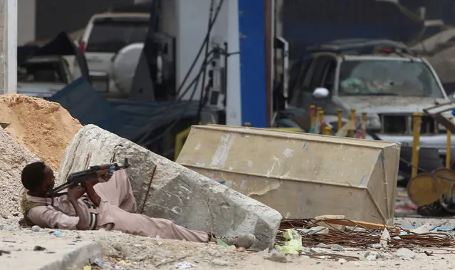 A Somali government soldier holds his position during gunfire after a suicide bomb attack outside Nasahablood hotel in Somalia's capital Mogadishu, June 25, 2016. (Photo by Feisal Omar/Reuters)