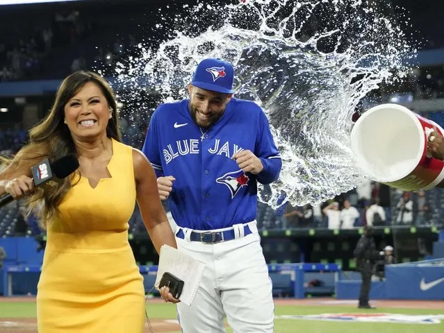 Sportsnet's Hazel Mae runs away as George Springer #4 of the Toronto Blue Jays is doused with water by Vladimir Guerrero Jr. #27 following a 7-2 over the Boston Red Sox at Rogers Centre on June 27, 2022 in Toronto, Ontario, Canada. (Photo by John E Sokolowski/USA Today via Reuters)