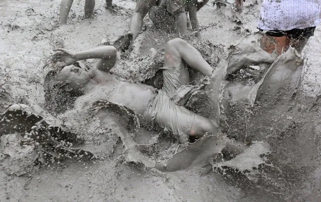 Festival goers plays in mud during the 15th Annual Boryeong Mud Festival at Daecheon beach in Boryeong, southwest of Seoul