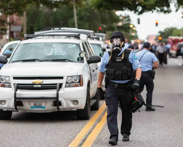 Police wear gas masks as they attempt to disperse a crowd that gathered after a shooting incident in St. Louis, Missouri August 19, 2015. (Photo by Kenny Bahr/Reuters)