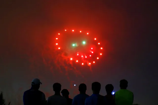 People watch fireworks in the form of a “smiley face” during the 4th of July Independence Day celebrations at the National Mall in Washington, U.S., July 4, 2016. (Photo by Carlos Barria/Reuters)