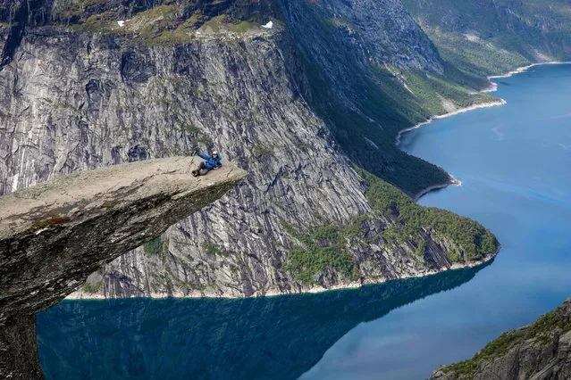 Tourists visit the rock “Trolltunga” in the county Hordaland in the western part of Norway, on June 21, 2017. About 150 000 tourists are expected to visit the spectacular mountain area this summer.  The name “Trolltunga” means “the troll´s tongue”. (Photo by Tore Meek/AFP Photo)