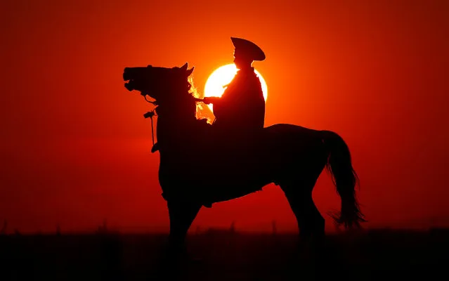 A traditional Hungarian horseman practices poses as the sun sets in the Great Hungarian Plain in Hortobagy, Hungary June 29, 2016. (Photo by Laszlo Balogh/Reuters)
