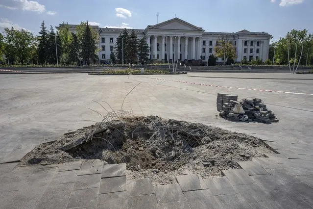 A crater in the aftermath of a Russian missile strike, in front of the city council hall building, in Kramatorsk city hall, eastern Ukraine, Saturday, July 16, 2022. Ukrainians living in the path of Russia's invasion in the besieged eastern Donetsk region are bracing themselves for the possibility that they will have to evacuate. (Photo by Nariman El-Mofty/AP Photo)