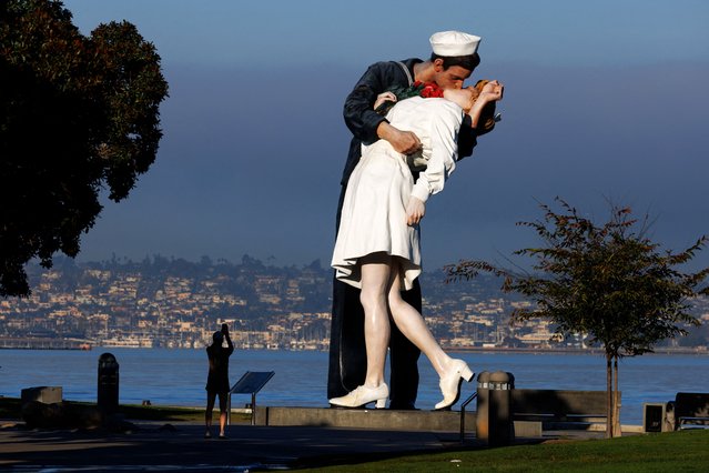 A morning jogger stops to take a picture of the sculpture “Embracing Peace” by Seward Johnson at its location near Naval Base San Diego on Veterans Day in San Diego, California on November 11, 2024. (Photo by Mike Blake/Reuters)