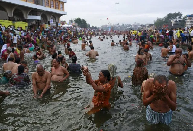 Hindu devotees pray while standing in the Godavari river during Kumbh Mela or the Pitcher Festival in Nashik, India, August 26, 2015. (Photo by Danish Siddiqui/Reuters)