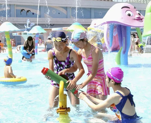 Labourers and youth visit Munsu Water Park during a continued period of hot weather in this August 8, 2014 photo released by North Korea's Korean Central News Agency (KCNA) in Pyongyang August 11, 2014. (Photo by Reuters/KCNA)
