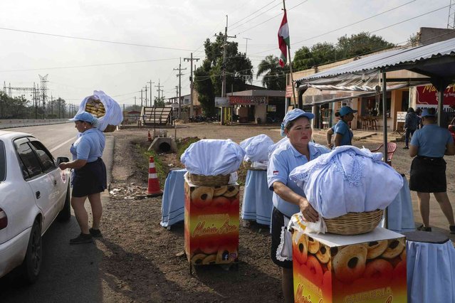 Vendors sell chipas, a traditional baked roll made with corn flour and cheese, from a roadside stand in Barrero, Paraguay, Friday, August 30, 2024. (Photo by Rodrigo Abd/AP Photo)