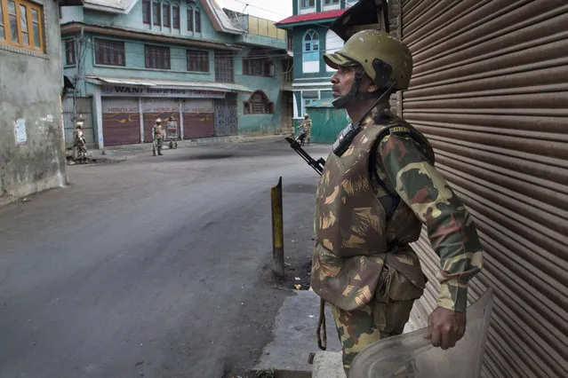 Indian paramilitary soldiers stand guard outside a closed market during the eleventh straight day of curfew in Srinagar, Indian controlled Kashmir, Tuesday, July 19, 2016. (Photo by Dar Yasin/AP Photo)