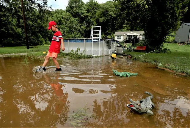 Brayden Bannister, 10, of Bourbon searches for lost items in his grandmother's flooded backyard on Thursday, August 4, 2022, along Romaine Creek Road near Hwy. 141 in Jefferson County, Mo. Heavy overnight rainfall caused flash flooding in the area. (Photo by Laurie Skrivan/St. Louis Post-Dispatch via AP Photo)