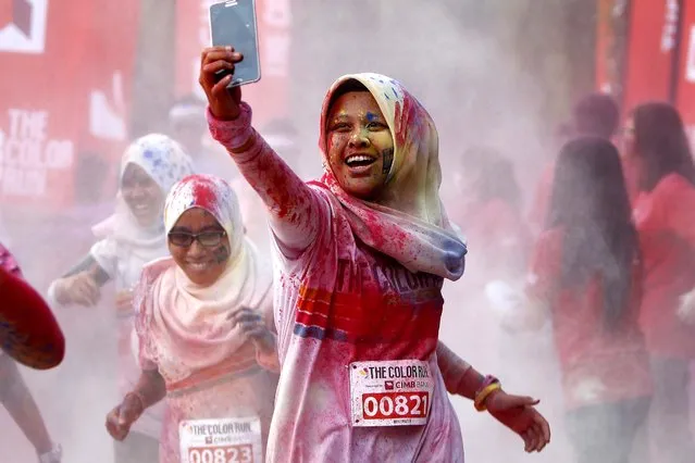 A participant takes a selfie as she runs through a “color station” during the five-kilometer color run event in Kuala Lumpur, Malaysia, Sunday, August 17, 2014. (Photo by Lai Seng Sin/AP Photo)