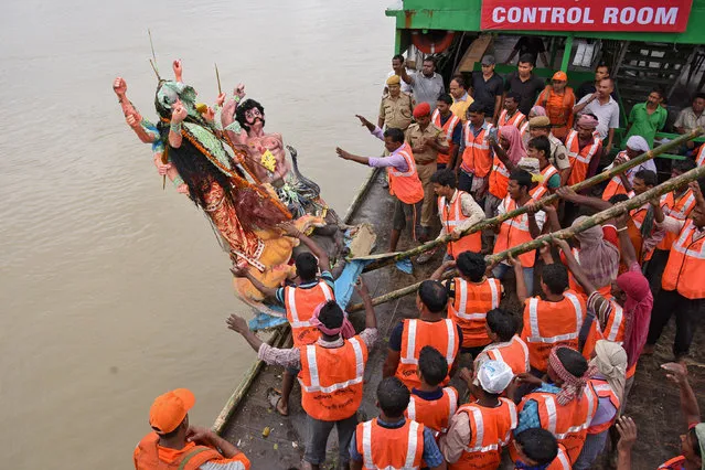 Municipal workers immerse an idol of the Hindu goddess Durga in the waters of the river Brahmaputra on the last day of the Durga Puja festival in Guwahati, September 30, 2017. (Photo by Anuwar Hazarika/Reuters)