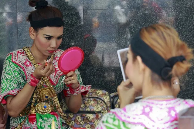 Thai classical dancers touch up their make-up before performing at the Erawan shrine in central Bangkok, Thailand, September 8, 2015. (Photo by Chaiwat Subprasom/Reuters)