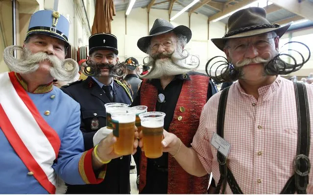 Participants have a beer as they take part in the 2012 European Beard and Moustache Championships in Wittersdorf near Mulhouse, Eastern France, September 22, 2012. More than a hundred participants competed in the first European Beard and Moustache Championships organized in France. (Photo by Vincent Kessler/Reuters)