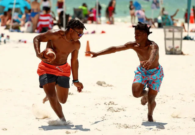 People visit Clearwater Beach on May 20, 2020 in Clearwater, Florida. Florida opened its beaches as part of Phase 1 its reopening, as Governor Ron DeSantis had previously said the state is working to build a foundation for Florida's future. (Photo by Mike Ehrmann/Getty Images)
