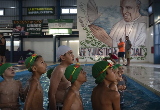 Children listen to a coach during a swimming lesson with a painting of Pope Francis in the background, in San Jose natatorium in Buenos Aires, Argentina, Tuesday, February 18, 2025. (Photo by Rodrigo Abd/AP Photo)