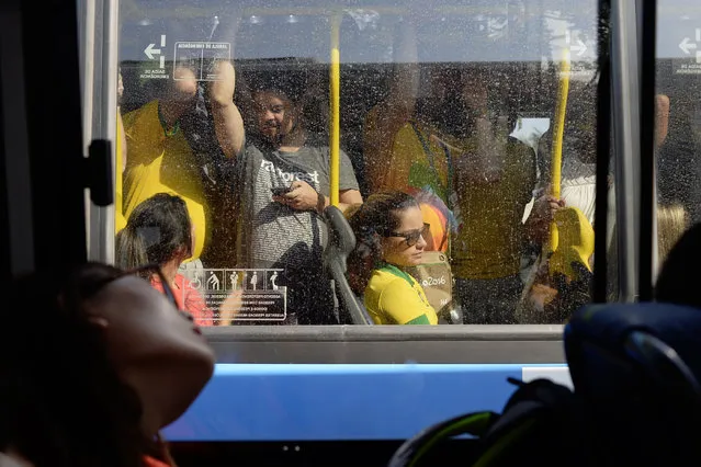 People are crammed onto a public bus as it passes the media transport shuttle outside of Olympic Park on Monday, August 15, 2016. (Photo by Aaron Ontiveroz/The Denver Post)
