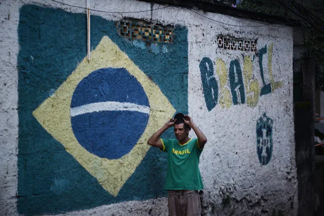 A man stands in a Neymar Jr. Jersey near a Brazilian flag mural during the men's gold medal soccer match between Brazil and Germany during Rio 2016 on Saturday, August 20, 2016. (Photo by Aaron Ontiveroz/The Denver Post)