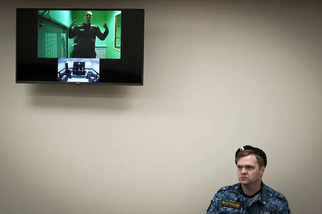 Russian opposition leader Alexei Navalny is seen on a TV screen as he appears in a video link provided by the Russian Federal Penitentiary Service in a courtroom of the Second Cassation Court of General Jurisdiction in Moscow, Russia, Tuesday, October 18, 2022. Earlier this year, Navalny was sentenced to nine years in prison on the charges of fraud and contempt of court. This is his second appeal of the conviction, he lost the first one in May this year. (Photo by Alexander Zemlianichenko/AP Photo)