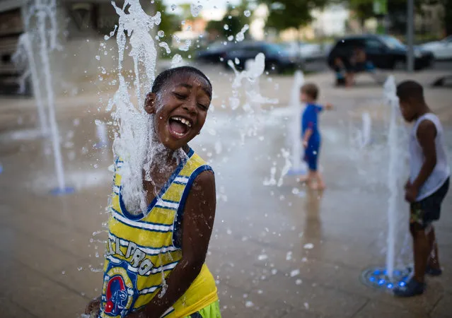 Meechie Gainey, 7, of DC, laughs as the water jets of the Canal Park sprayground hit him in the face on July 7, 2016. The spray ground at Canal Park is an interactive water fountain with programmable water jets embedded below the pavement that are illuminated in many colors. The park at 200 M St. SE was built on the site of the historic Washington Canal in the heart of DC's Captiol Riverfront neighborhood. It (Photo by Sarah L. Voisin/The Washington Post)