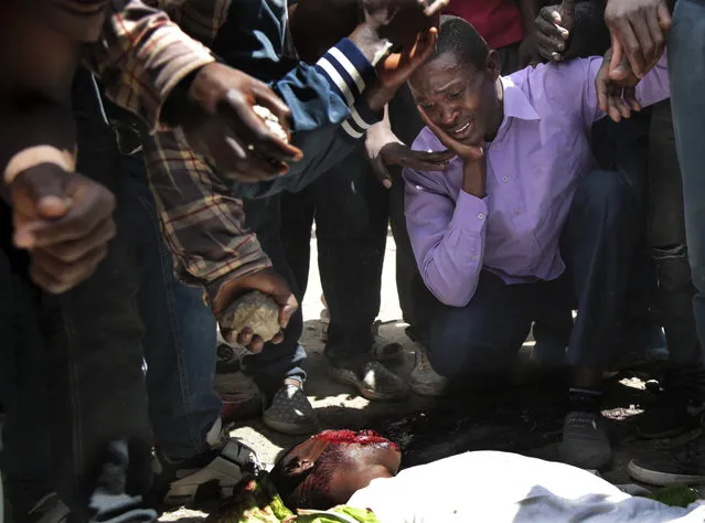 Opposition supporters react near the body of a man allegedly killed by a stray bullet fired by police, during clashes in the Jacaranda grounds quarter in Nairobi, Kenya, Tuesday, November 28, 2017. Kenyan President Uhuru Kenyatta was sworn in for a second term Tuesday in front of tens of thousands who gathered to celebrate what they hoped would be the end of months of election turmoil, which Kenyatta said stretched the country “almost to the breaking point”. (Photo by Brian Inganga/AP Photo)