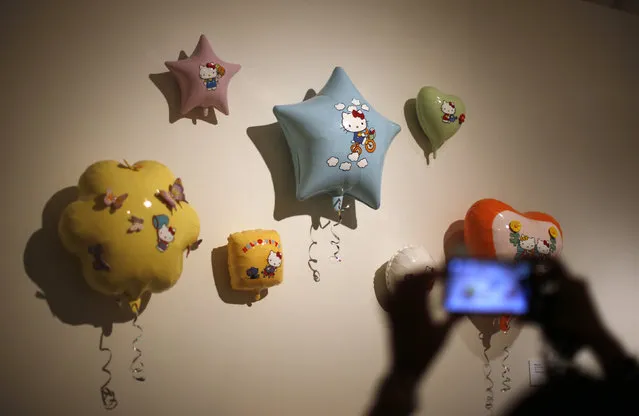 A woman photographs an exhibit at the “Hello! Exploring the Supercute World of Hello Kitty” museum exhibit in honor of Hello Kitty's 40th anniversary, at the Japanese American National Museum in Los Angeles, California October 10, 2014. (Photo by Lucy Nicholson/Reuters)