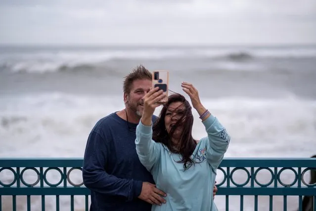 A couple take a selfie as waves crashes behind following the passage of Hurricane Nicole in Vero Beach, Florida, U.S. November 10, 2022. (Photo by Ricardo Arduengo/Reuters)